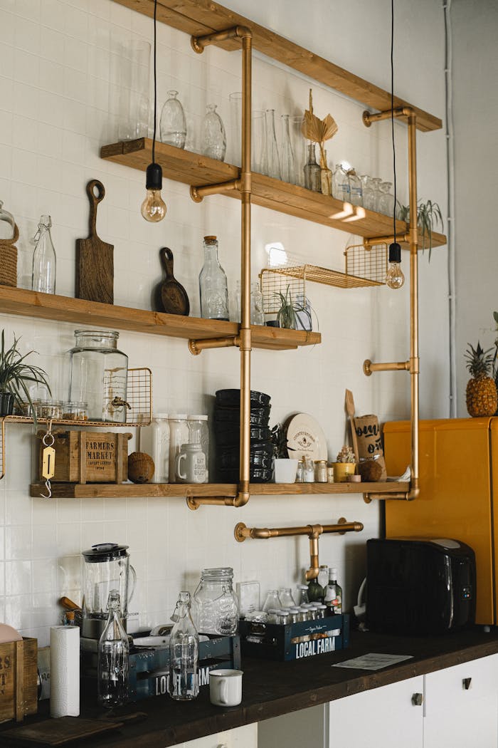 Interior of kitchen with different glass bottles and kitchenware placed on timber shelves